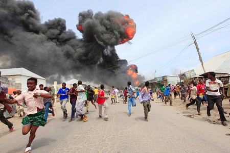 People escape from the direction of a huge fire-ball after an accidental explosion at a petrol storage facility within the former U.S. residential housing in Mogadishu